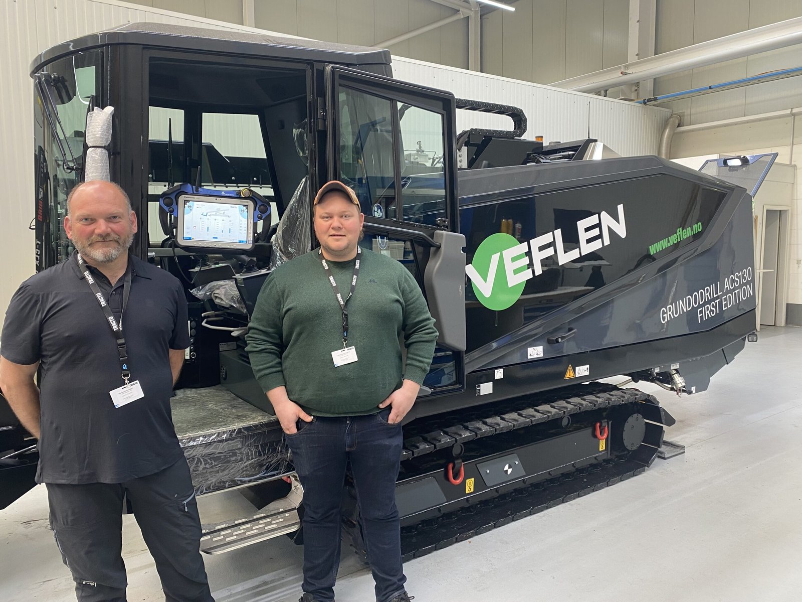 bilde av to menn foran en maskin