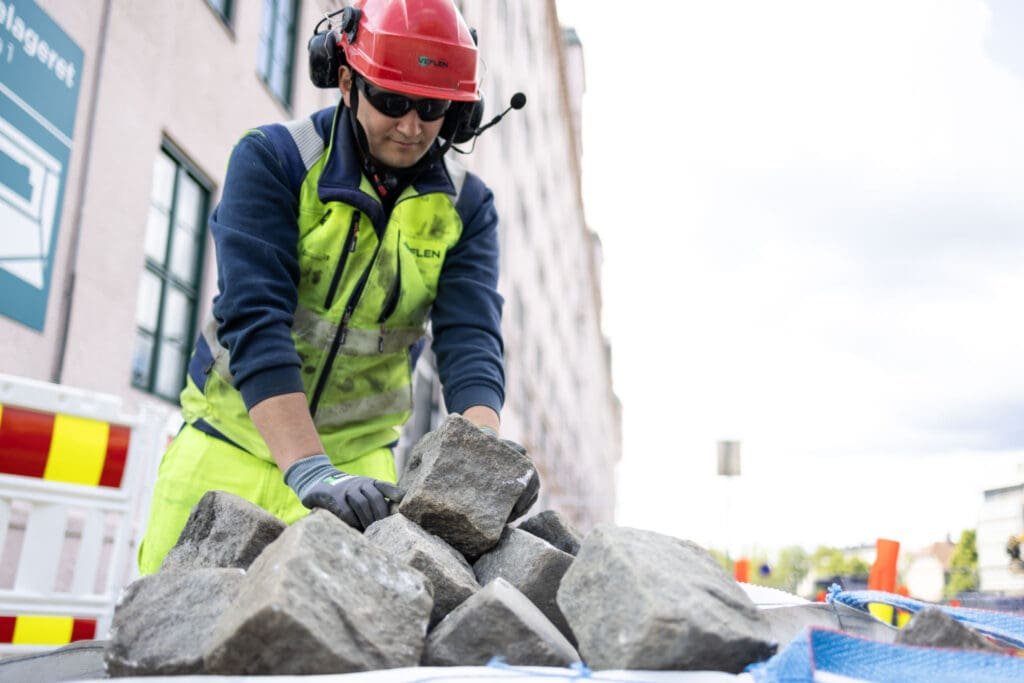 Jakob Fossen håndterer steinblokker under arbeid hos Veflen Entreprenør.