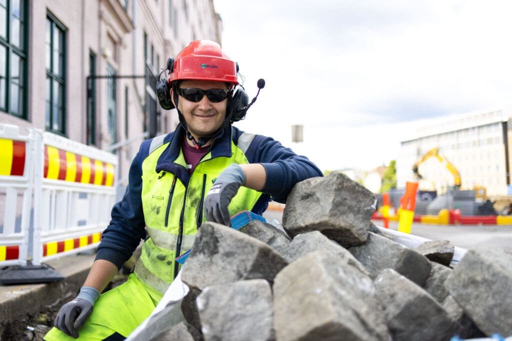Jakob Fossen håndterer steinblokker under arbeid hos Veflen Entreprenør.